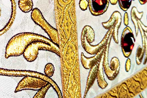 Gold religious embroidery on a white liturgical chasuble